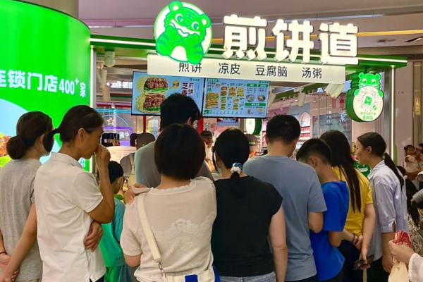清晨七点半，写字楼下的煎饼道门店前已排起长队。白领一手扫码支付，一手接过热腾腾的杂粮煎饼，金黄饼皮裹着脆嫩生菜和酱香薄脆，三分钟完成一单——这就是小吃快餐行业的“黄金矿脉”。